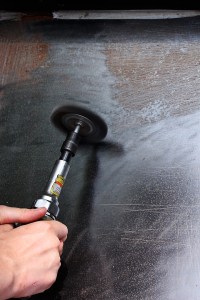 Removing the rust from the welded plate.